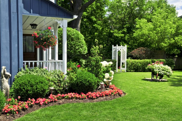 Nice landscaping adds curb appeal to your home Nice home landscaping with a row of red flowers