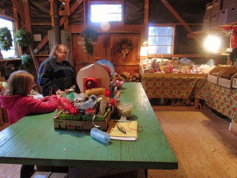 A few guests look over the worktable where the bows are made